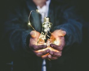 Man holding a lightbulb with fairy lights idea