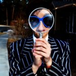 model with a magnifying glass on her face