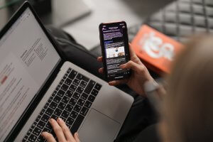 person using a mobile and laptop